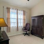 Office with desk to the right, office chair, and TV on stand with lamp on the left side.

Looking East.
