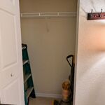 Storage closet with ladder and Dyson vacuum in the corner of the family room.

Looking West.